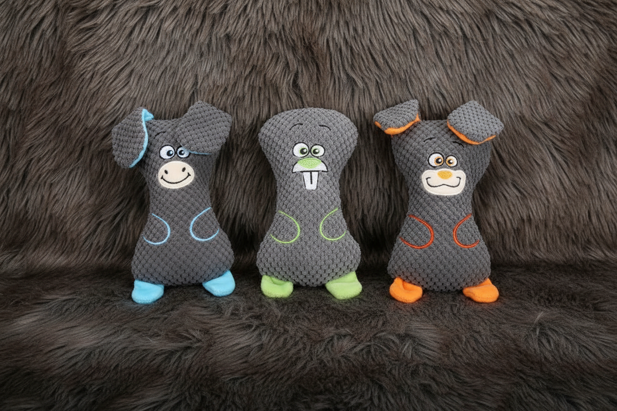 All 3 gray waffle plush squeaky dog toys side by side on faux fur